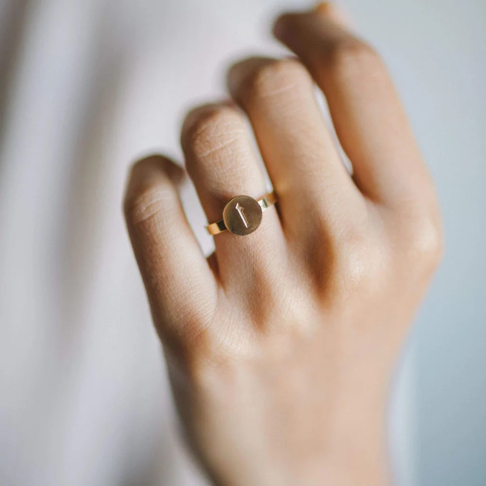 Person wearing gold personalized ring with engraved Arabic Alif letter initial on index finger