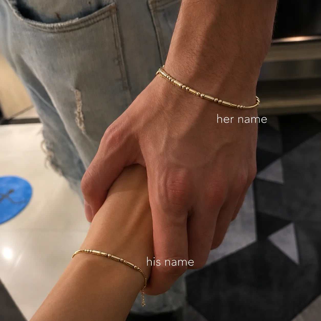 Couple holding hands wearing matching Morse Code Bracelets with personalized name engraving, a minimalist jewelry design for everyday wear.