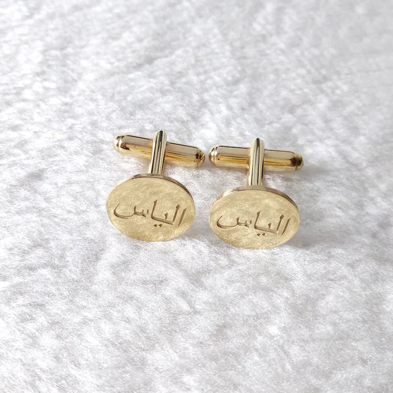 Personalized Arabic name cufflinks featuring custom engraved Arabic lettering on oval faces in a polished golden finish.