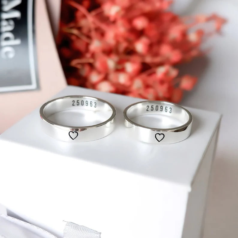Custom engraved silver couple rings with matching polished bands, heart details and personalised inner engraving for couples.