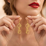 Personalized name drop earrings featuring custom script lettering in an elegant elongated design, shown in a golden finish.