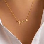 Close up of woman wearing gold chain necklace with personalized Hannah cursive name pendant