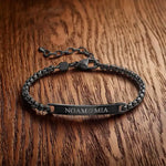 Personalized black bracelet with custom engraved names on a curb chain.
