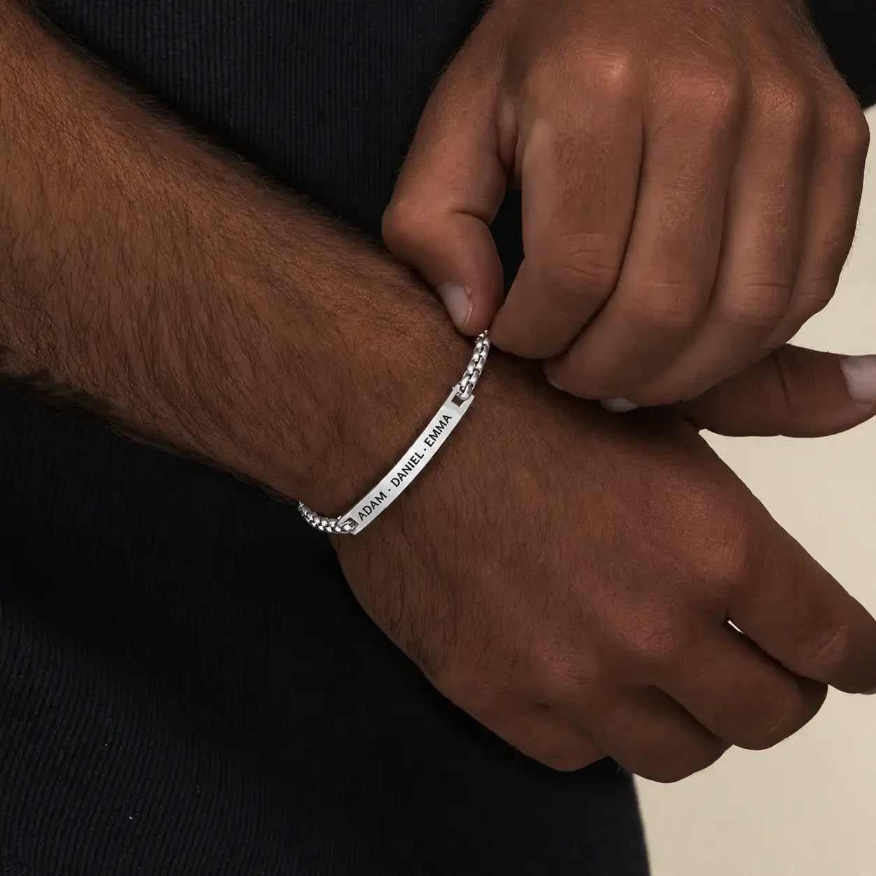 Personalized silver bracelet with custom engraved names on a curb chain.