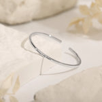 Silver engraved cuff bracelet with the message "Always in My Heart" on a minimalist open bangle.
