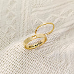 Gold couple rings with custom names engraved inside and a heart cutout detail
