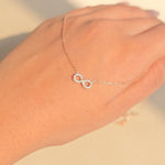 A delicate chain bracelet with two interlocking infinity symbols