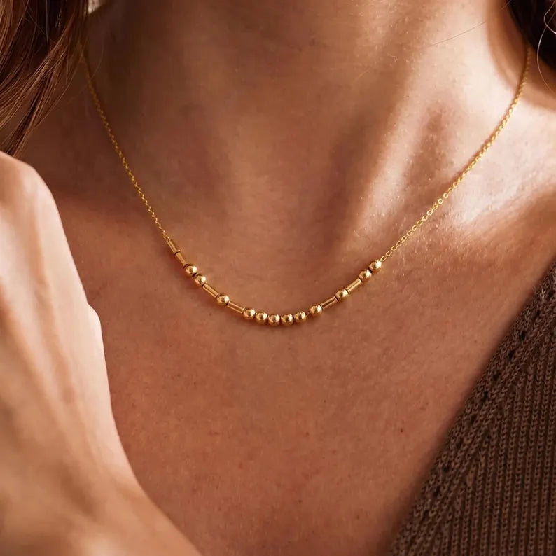 Personalized Morse code name necklace featuring a delicate beaded design with metal accents, styled as a minimalist everyday accessory.