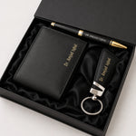 Premium black leather wallet gift set with matching keychain and pen featuring gold accents in an elegant presentation box.