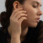 Woman wearing thin gold band ring with custom script nameplate on ring finger