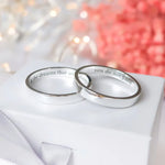 Custom engraved 3mm silver rings with personalised messages inside, shown as matching minimalist bands for couples.