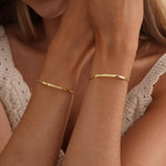Personalized engraved cuff bracelet with custom wording on a slim open-band design, shown in a golden finish.