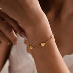 Personalized heart name bracelet with two custom engraved heart charms on a delicate chain, available in golden and silver finishes.