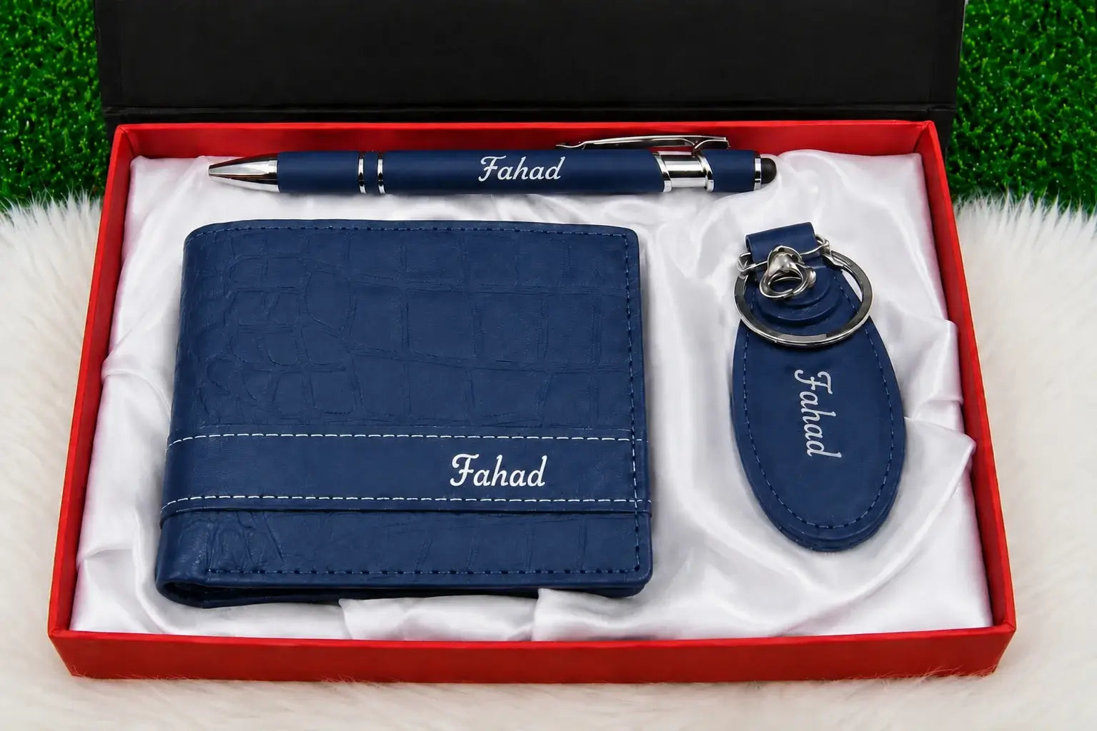 Blue leather wallet with matching personalized pen and keychain arranged in a red gift box