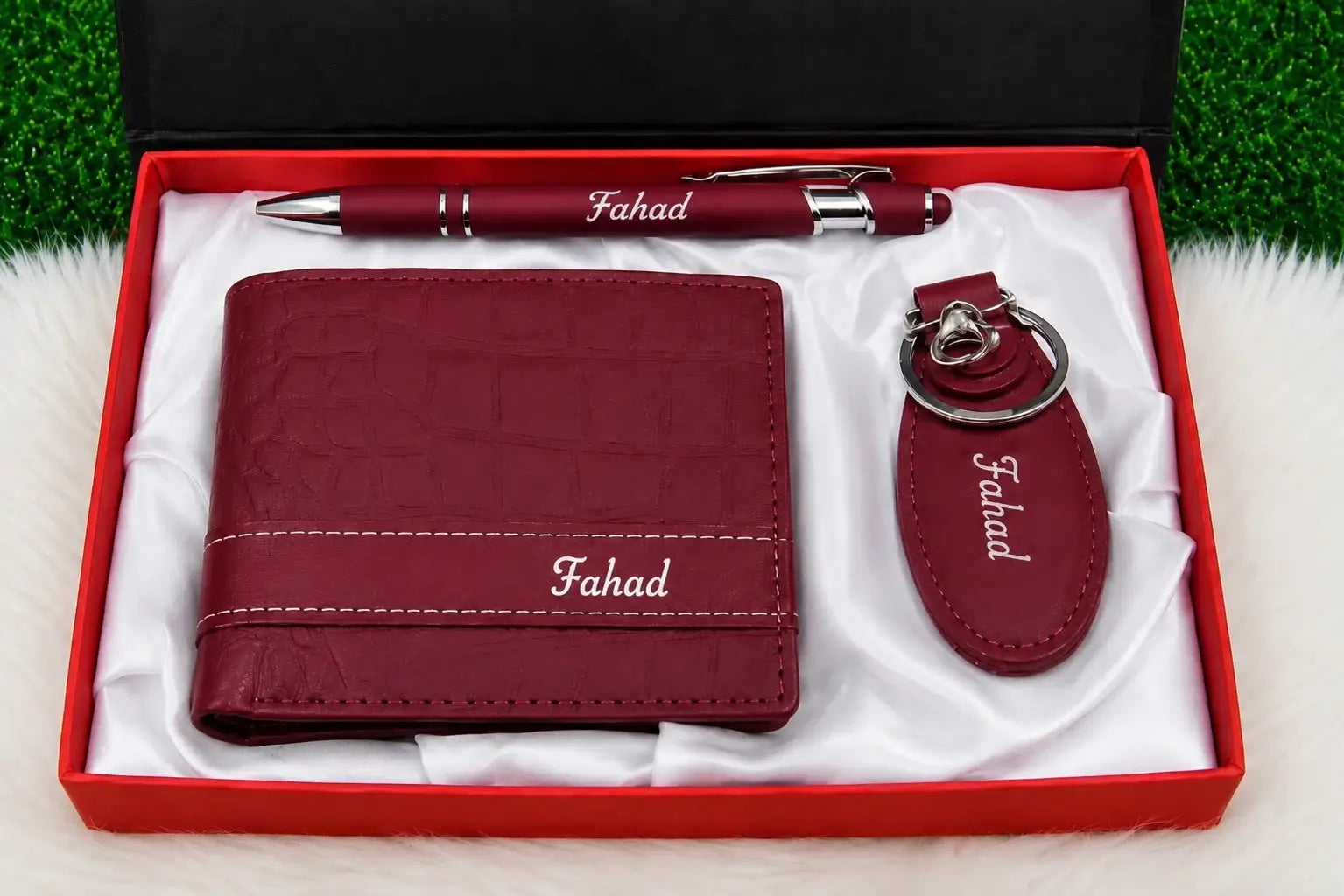 Maroon wallet, matching keychain and pen arranged in a white satin-lined gift box with Fahad personalization