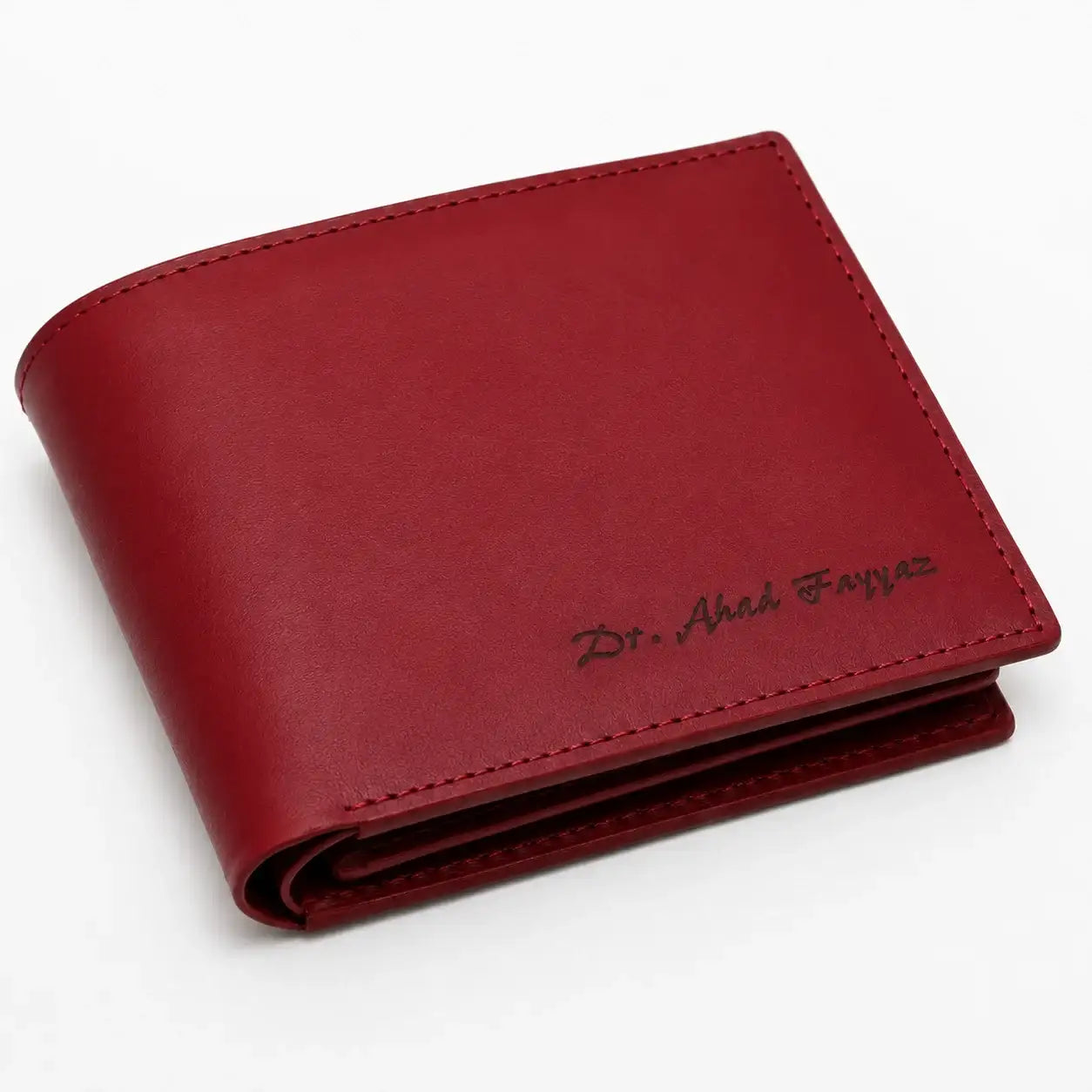 Maroon red leather bifold wallet personalized with a custom name, featuring a clean finish and refined stitching for everyday use