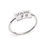 A silver ring with a rectangular top plate engraved with the date '17.06.