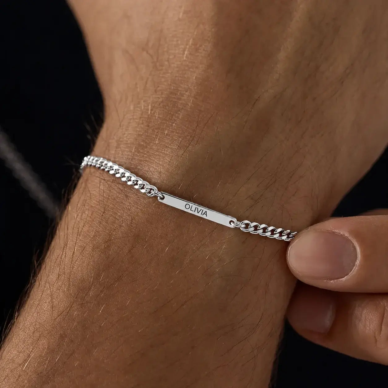 Personalized silver bar bracelet with a custom engraved name on a curb chain