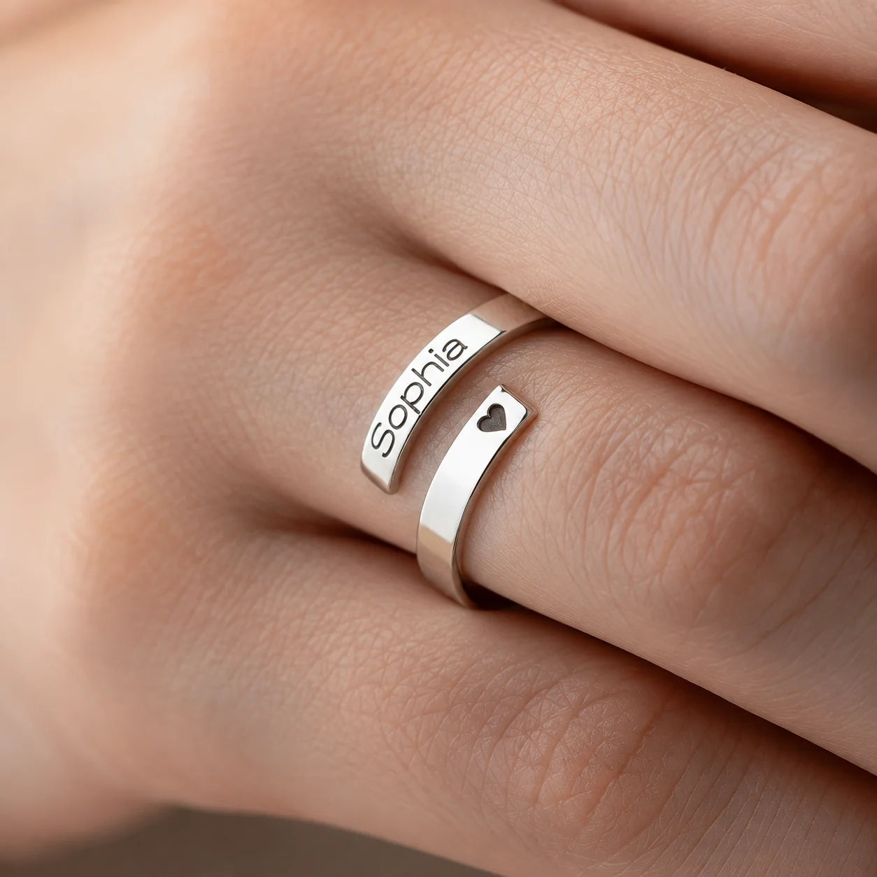 Personalized silver open ring engraved with Sophia and a heart cutout on a finger
