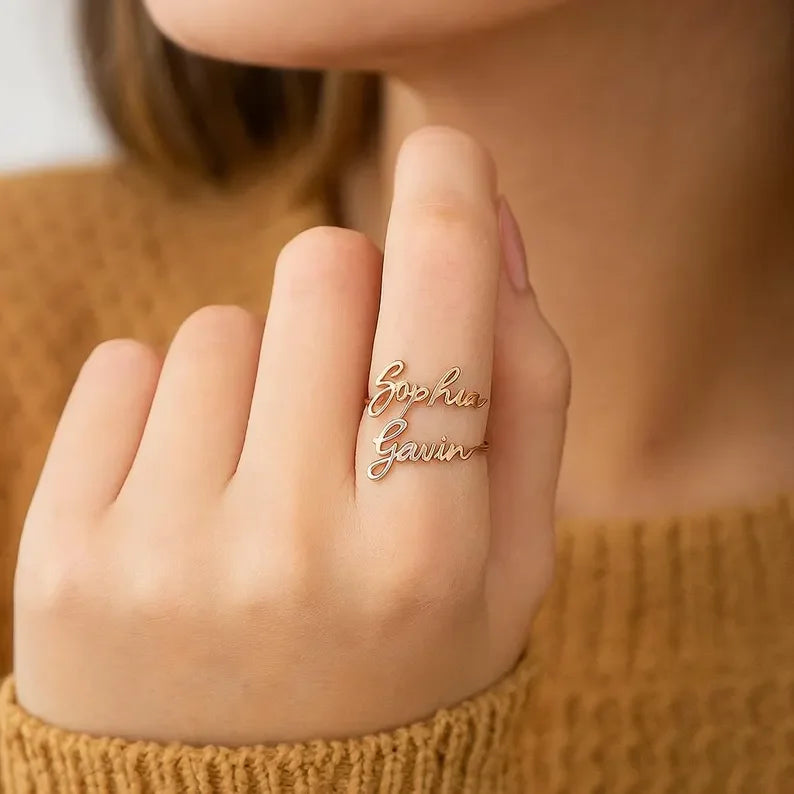 Woman wearing rose gold two name ring with Sophia and Gavin cursive script nameplates stacked on finger
