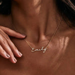 Woman wearing thin gold chain necklace with Emily cursive script nameplate