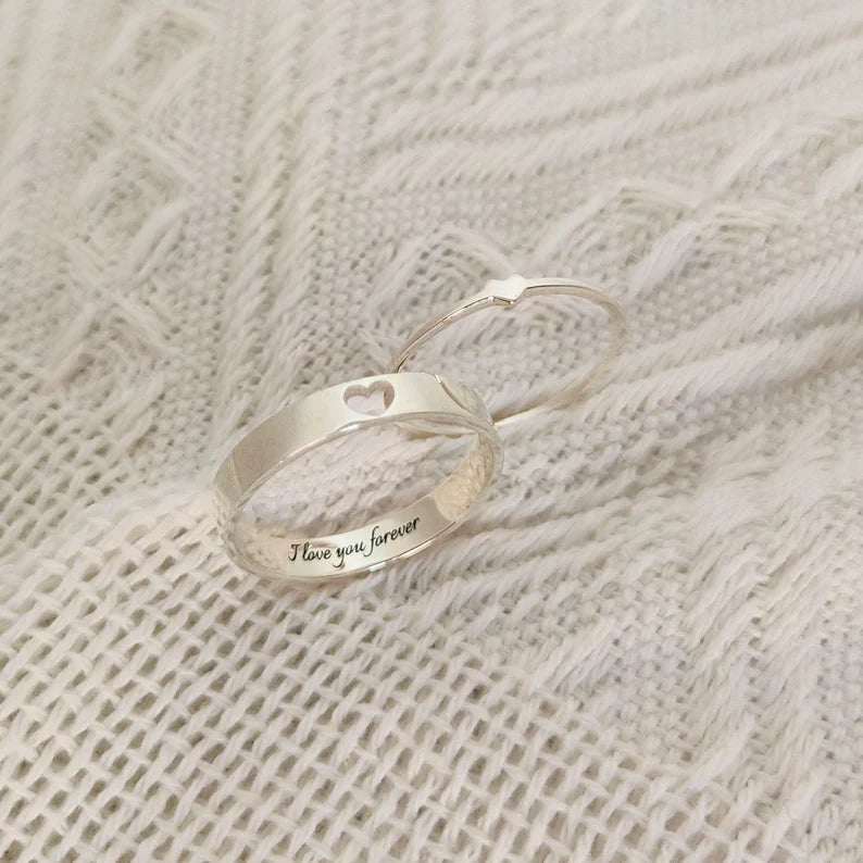 Silver couple rings featuring a heart cutout and personalized inner engraving