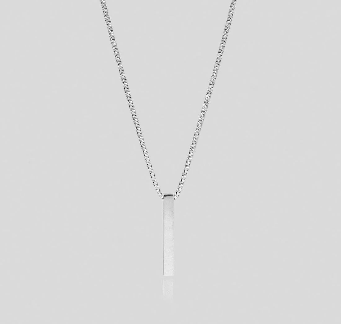 Silver box chain necklace with plain vertical 3D bar pendant on light grey background