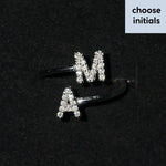 Silver open band initial ring set with rhinestone M and A letters on black velvet background