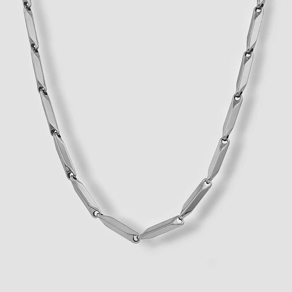 Silver chain with elongated bevel-cut bar links hanging against light grey background