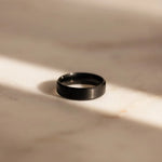 Black ring on a beige marble surface