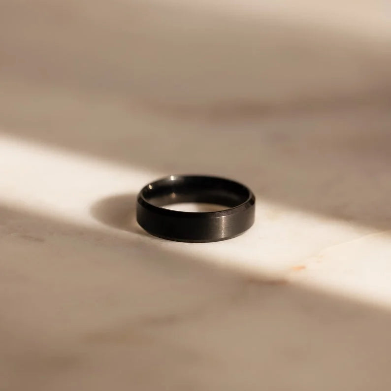 Black ring on a beige marble surface